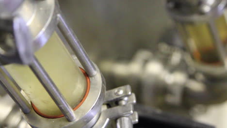 macro shot of beer filtering in tank showing color and liquid of beer in industrial factory