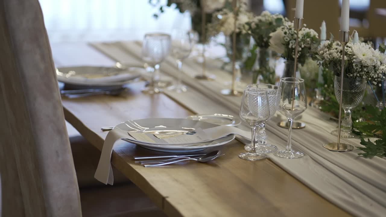 Wedding table setup with floral decor, candles, and elegant glassware arrangement