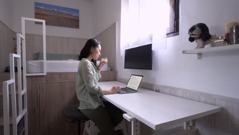 Asian-writer-with-laptop-and-coffee-at-home