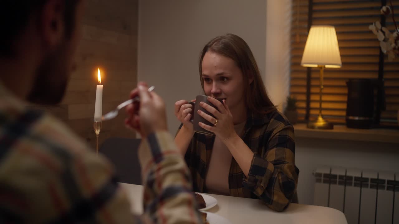 Um casal a desfrutar de um jantar romântico em casa.
