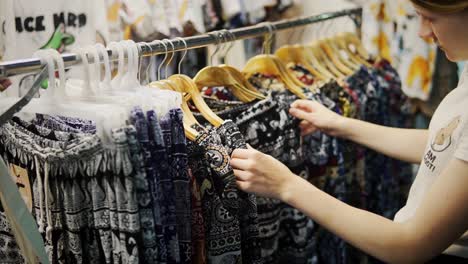 tourist shopping for elephant pants and clothes in thailand market