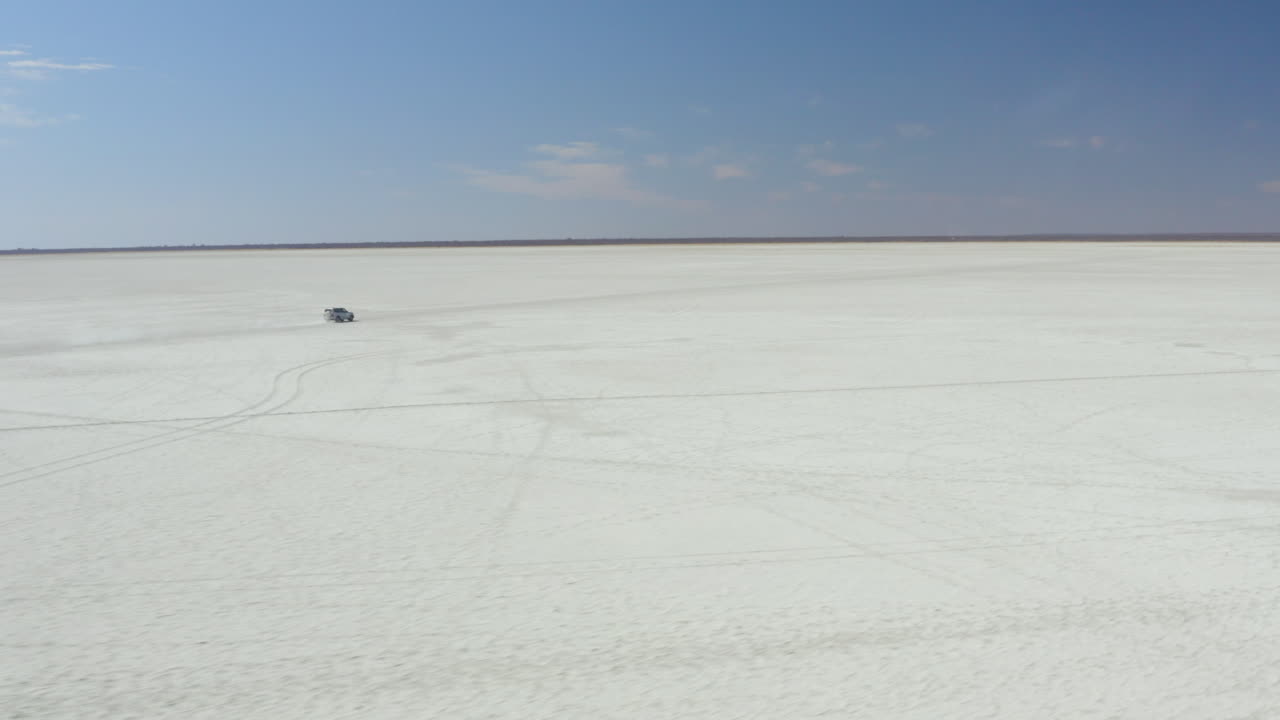 보츠와나의 쿠부 섬 근처 광대한 염전을 여행하는 자동차의 고립된 전망