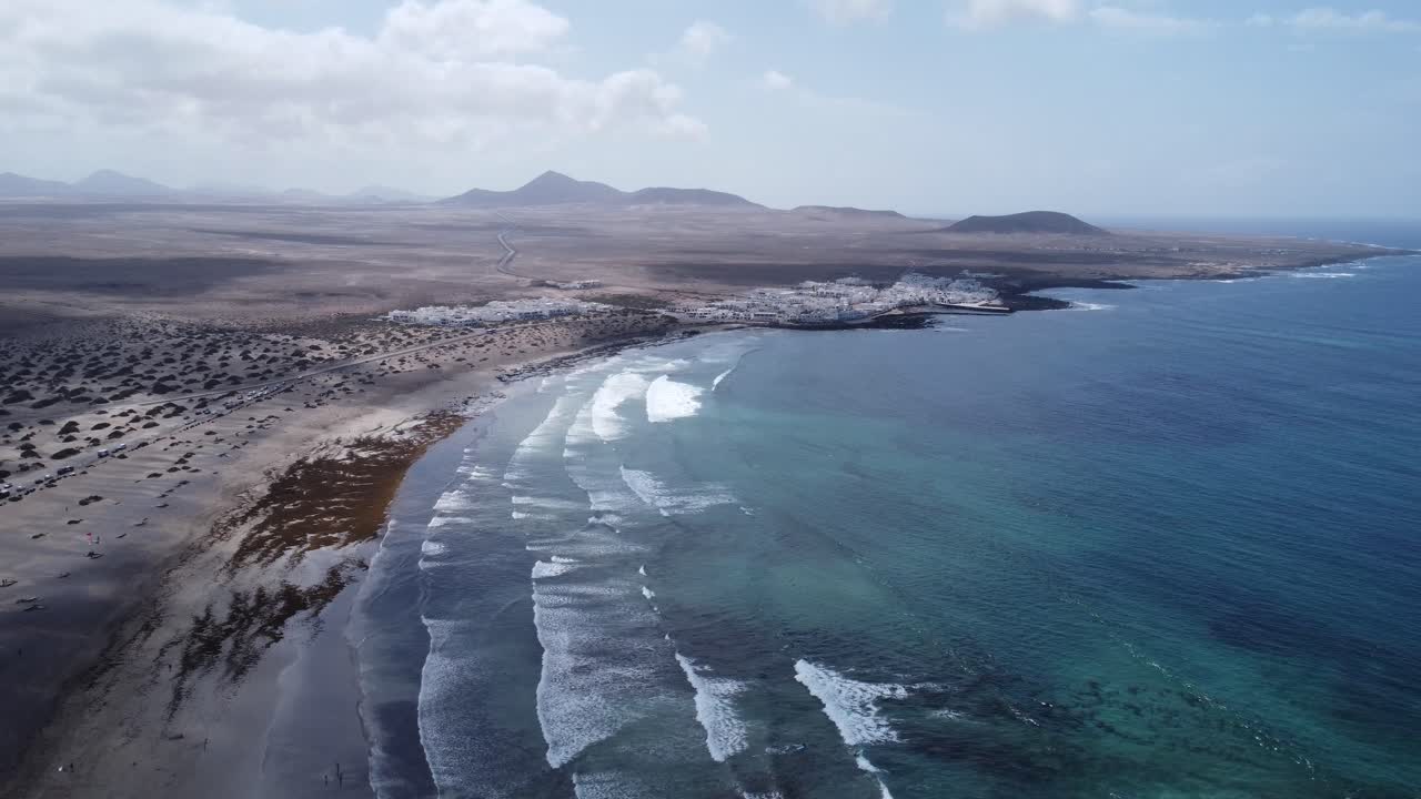 increíble bahía de arena de famara en lanzarote , olas y cielos azules