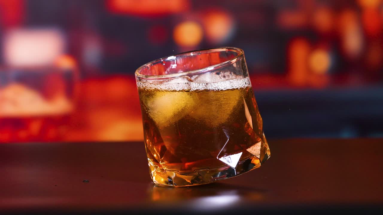 whisky vertiendo en un vaso con hielo