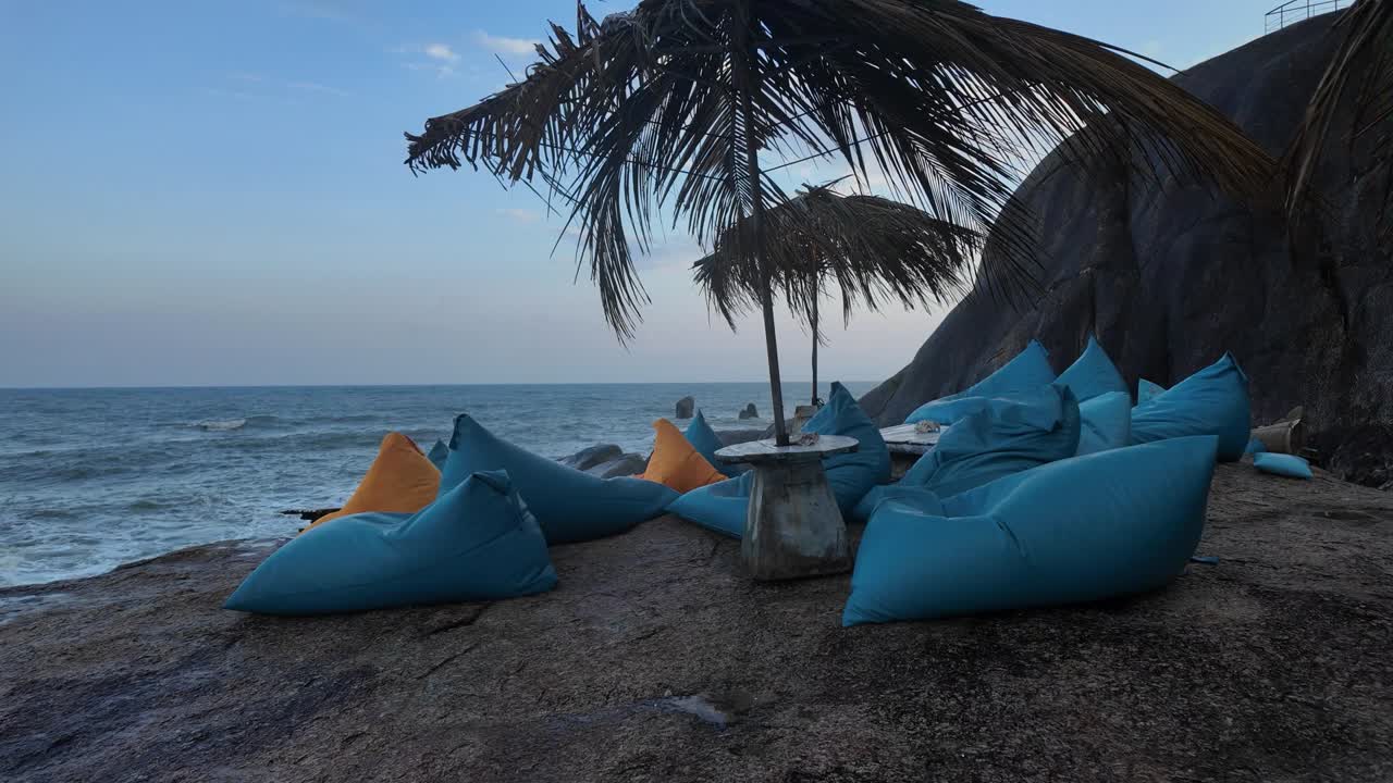 Blue Lounge Chairs with Yellow Pillows on Sandy Beach with Palm Trees, Summer Night
