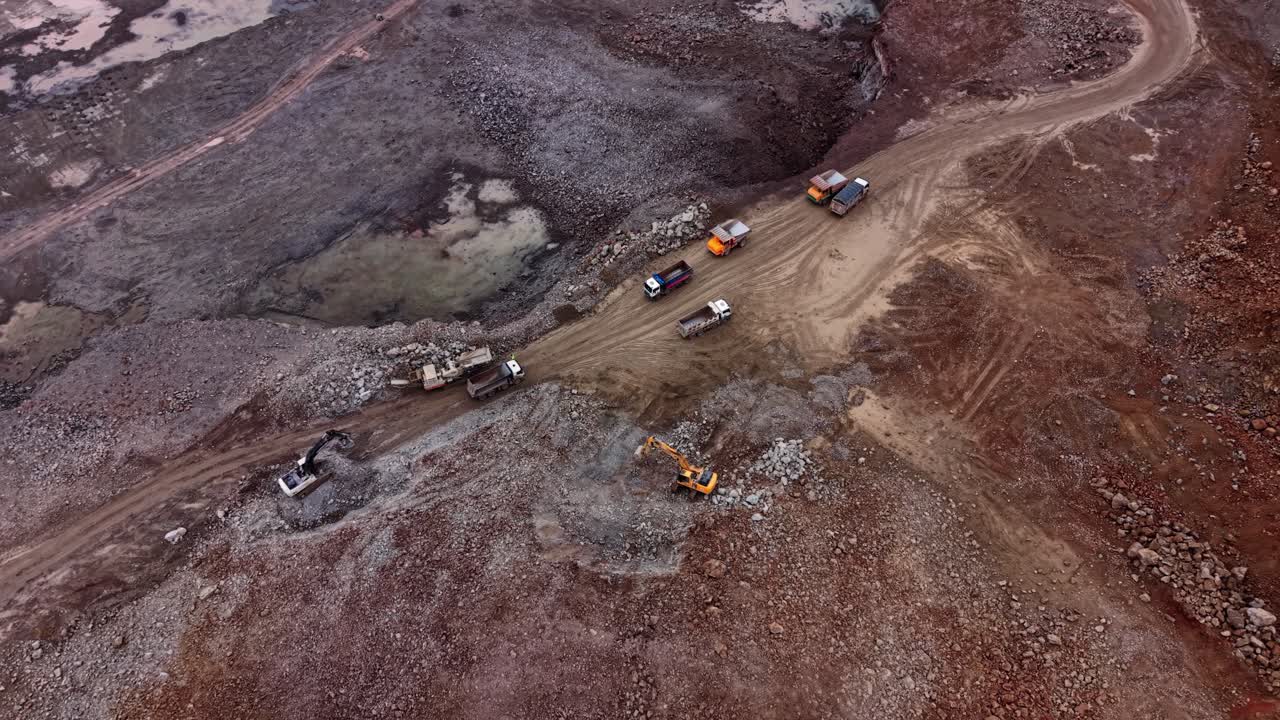 Granite quarry operation with heavy machinery on rocky terrain