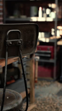 a close-up of a rusty metal chair in a workshop