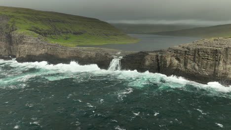 lago panorámico aéreo de retroceso por encima del océano día nublado islas feroe