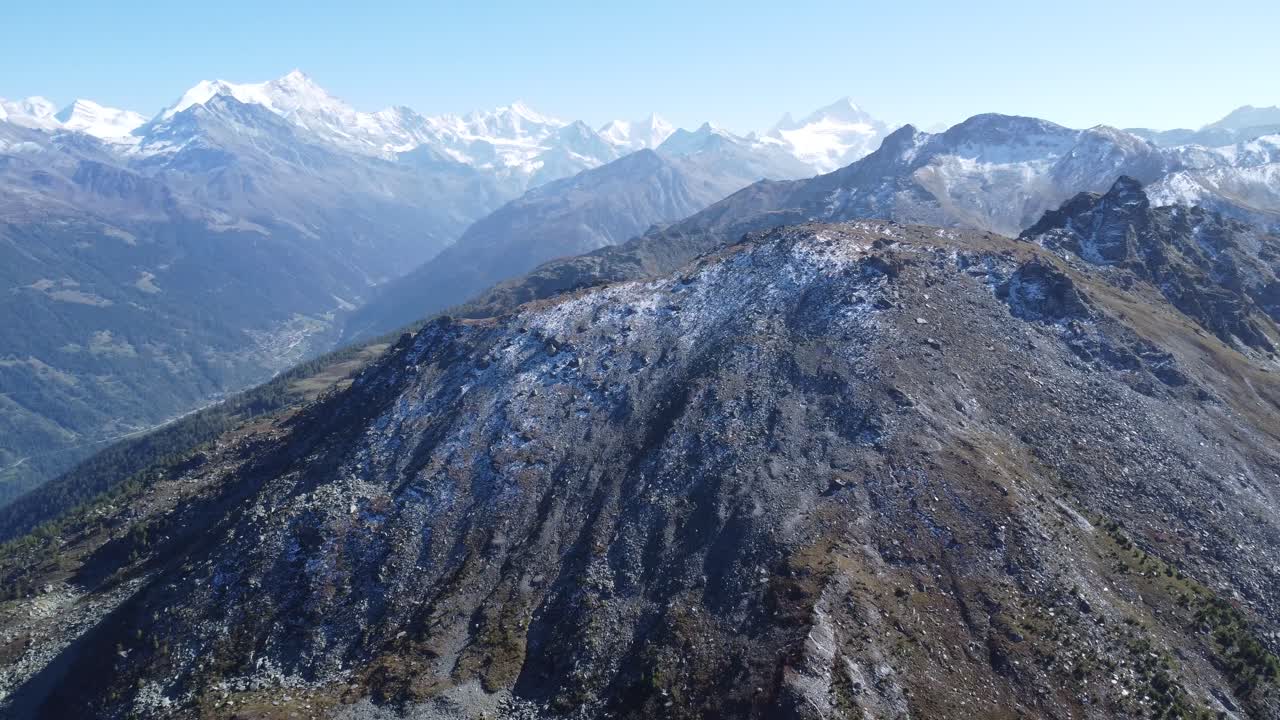 una gran roca frente a las montañas nevadas en los alpes suizos, dron aéreo