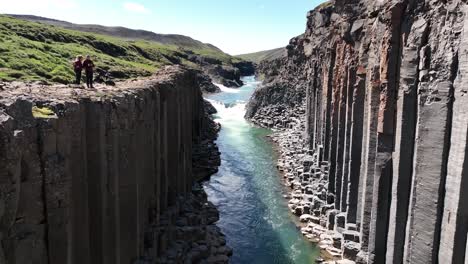 flying between basalt columns in studlagil canyon in east iceland - tourist editorial