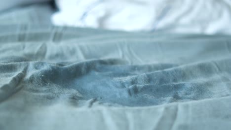 unmade bed with grey sheets