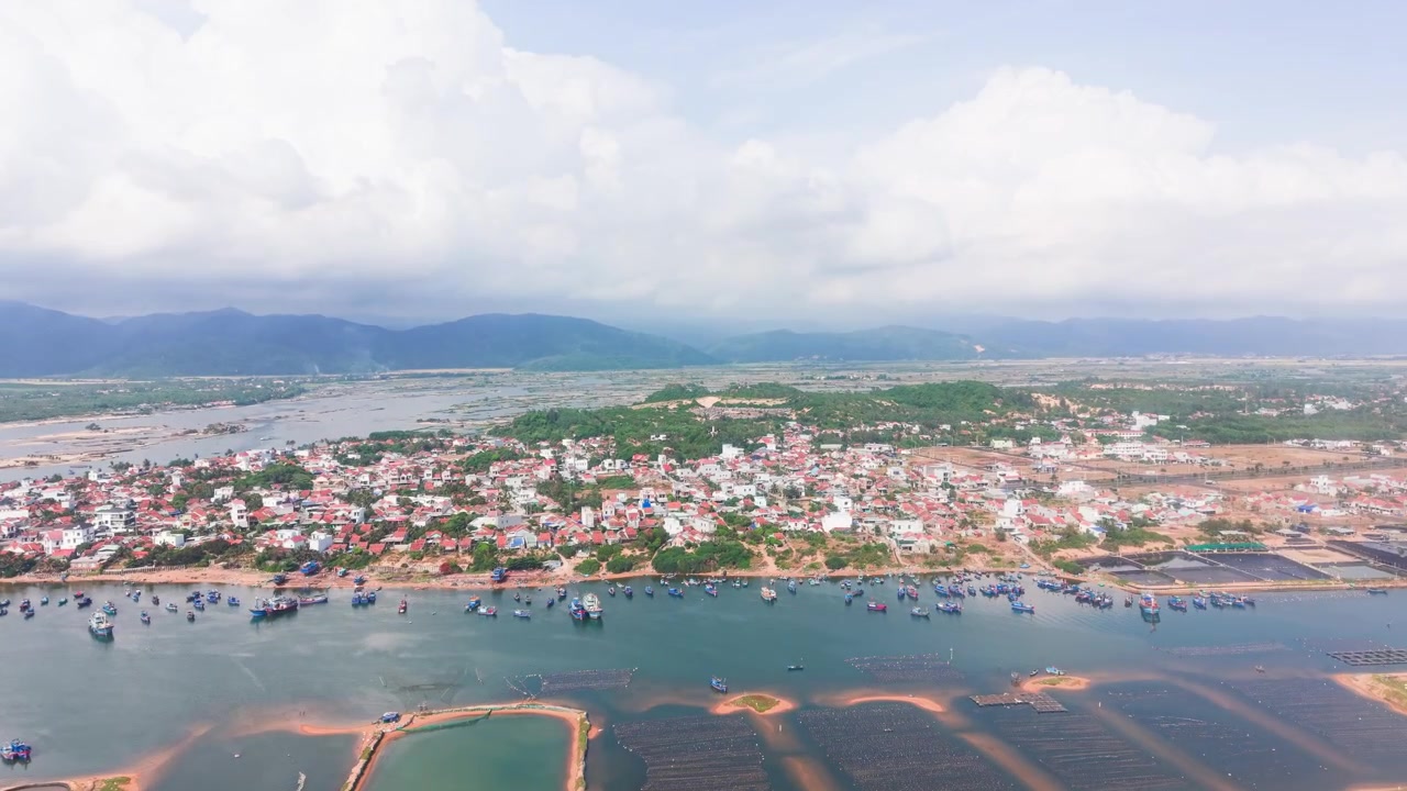 Isso captura Bien Lo Quang no Vietnã de cima, mostrando águas claras, praias de areia e cidades próximas. Destaca a paisagem natural e a vida local