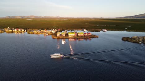 boat driving on lake titicaca in peru at sunset