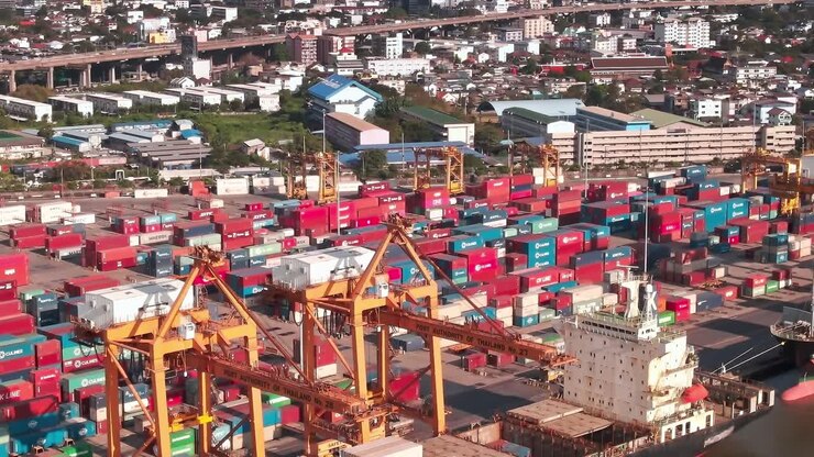 Busy shipping port in Bangkok with containers and city skyline