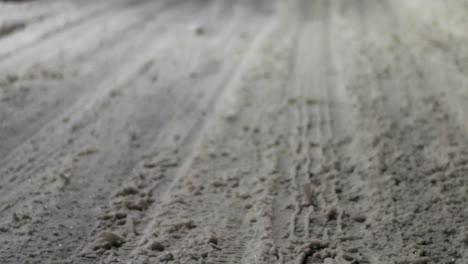 Pan-shot-of-a-street-covered-in-snow,-with-tire-tracks-during-the-night