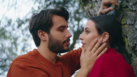 Loving-man-stroking-woman-in-forest-vertical-close-up.-Romantic-weekend-in-park.