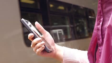 Businesswoman-using-phone-on-train-platform