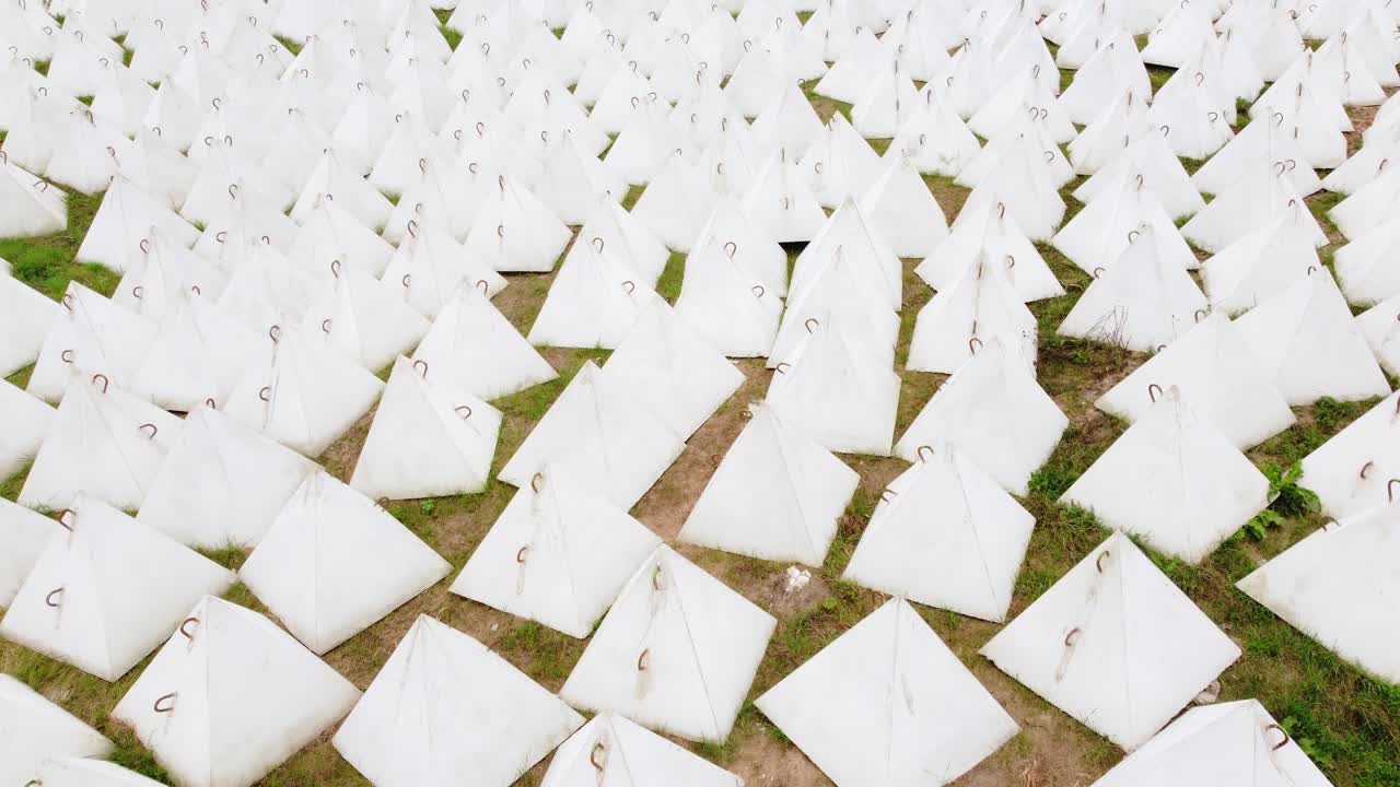 Many white pyramids called dragon teeth to protect against tanks, aerial view