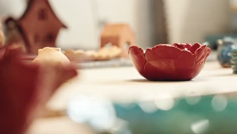 Unique-clay-pots-just-finished-on-table-of-craftsman,-moving-shot