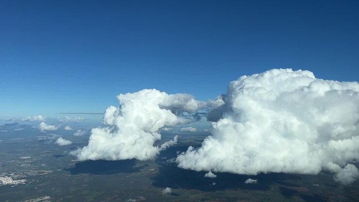 Flying toward two white cumulus clouds during the descent to Palma de Mallorca’s island, Balearic islands, Spain