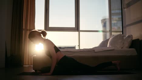 blonde caucasian woman practicing yoga at home, sitting on the floor on a yellow mat, changing poses - pigeon pose to dog pose and sits in lotus with namaste. slow motion