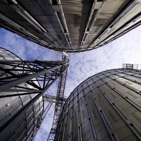 metal tanks of elevator. grain-drying complex outdoors. commercial grain silos on sky background. steel storage for agricultural harvest. close-up.