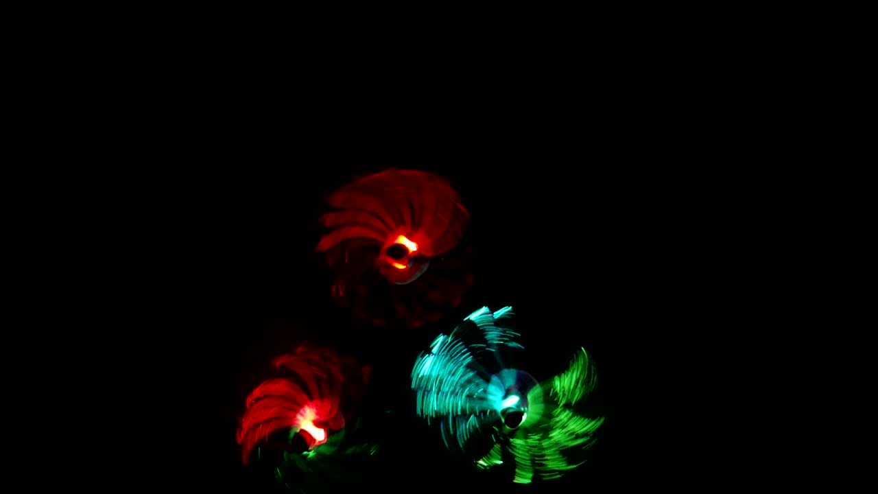 niñas bailando con disfraces de led en la noche al aire libre.