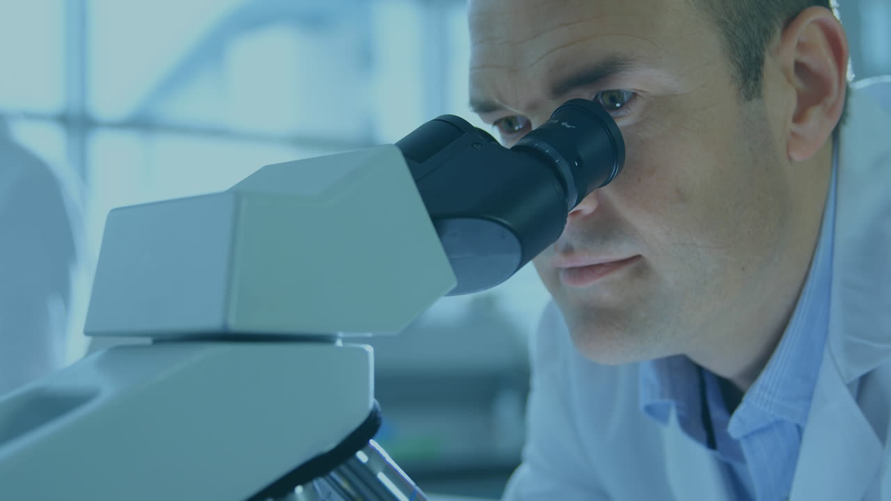 Animation of scopes scanning and data processing on screens over male scientist using microscope