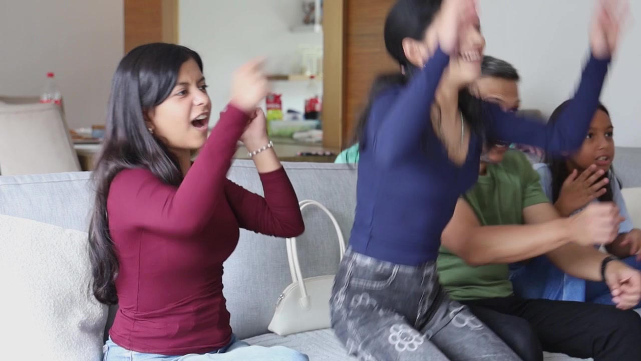 Family Cheering and Celebrating While Watching Sports on TV