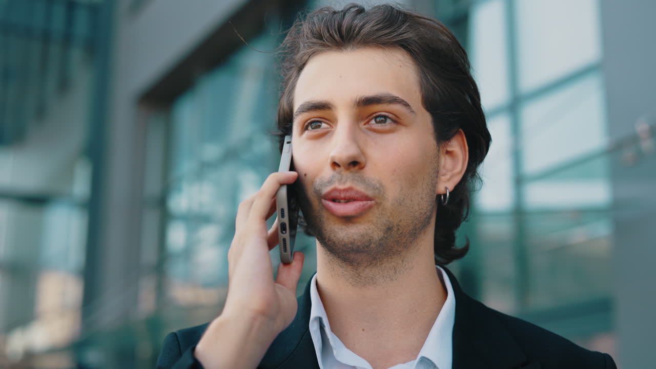 Young Man Talking on a Smartphone Outdoors in an Urban Setting