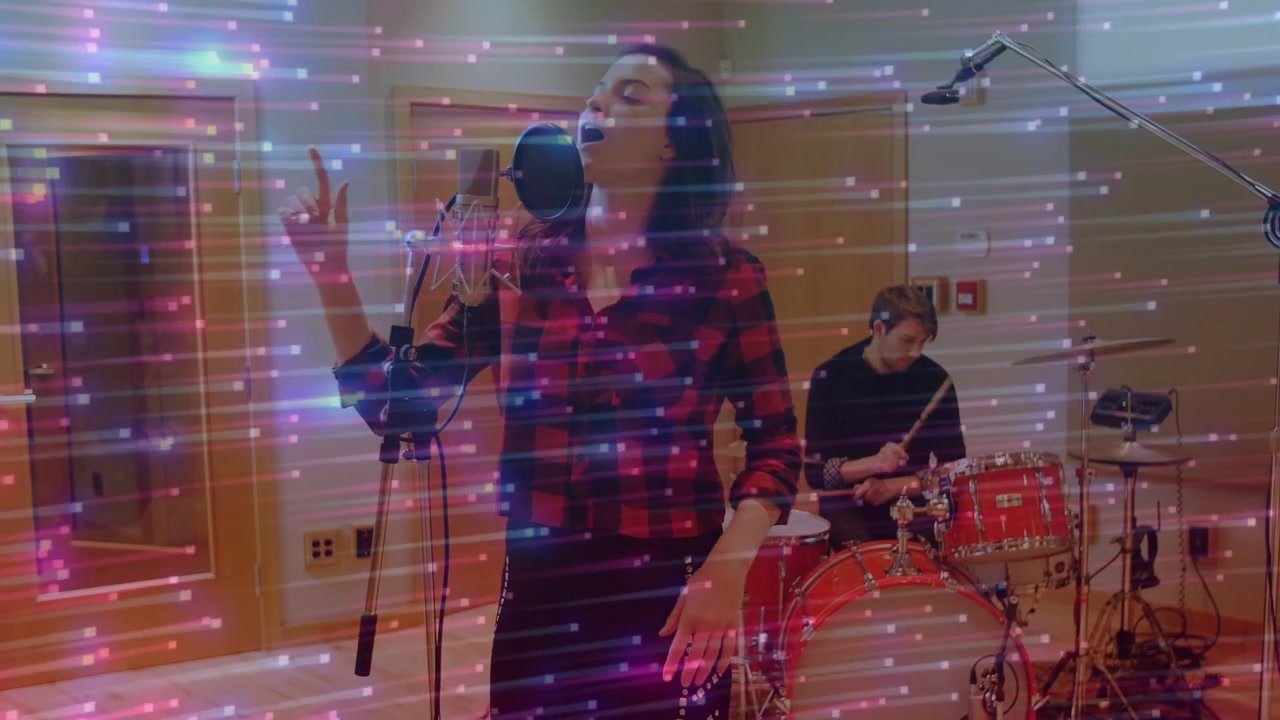 Baterista iniciando a batida, vocalista se inclinando para o microfone com filtro anti-pop, gravando a música enquanto rastros se sobrepõem.