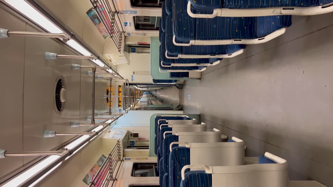 Interno di treno vuoto con sedili blu e pareti bianche a Buenos Aires, inquadratura verticale