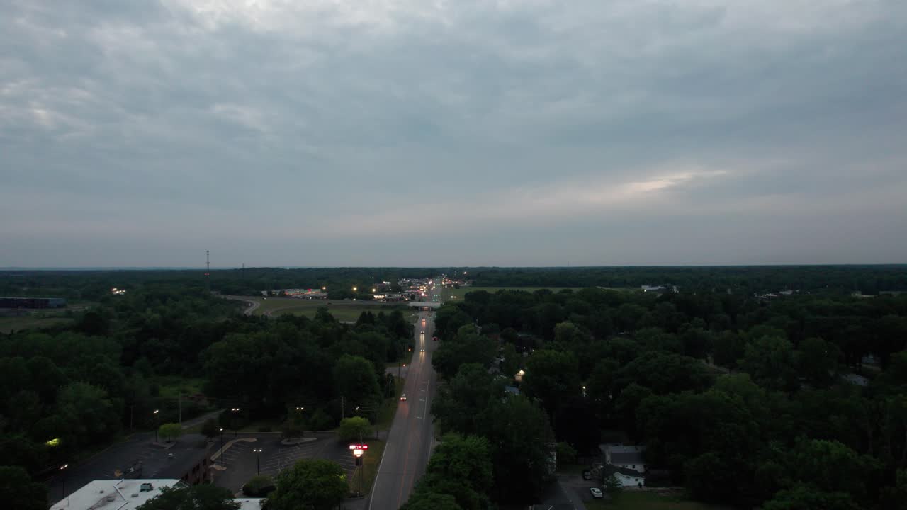 una foto de un dron de un hermoso paisaje con hierba verde y árboles al atardecer