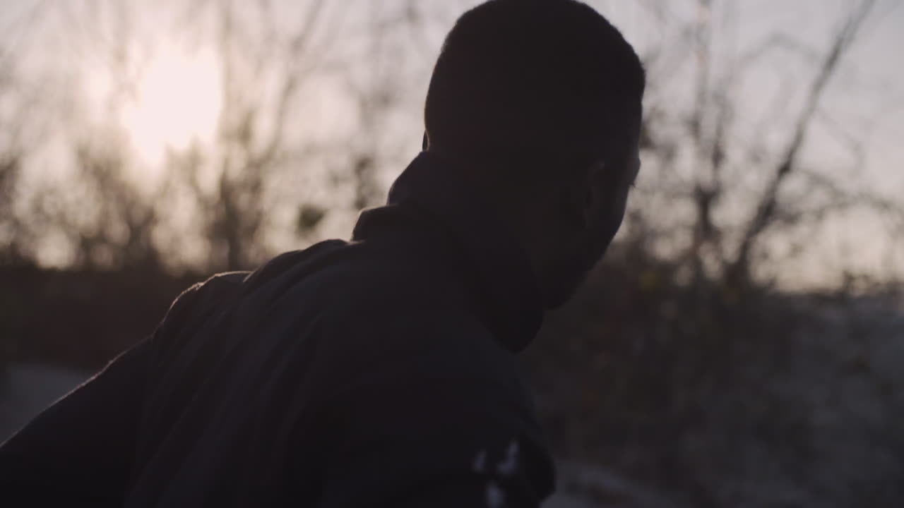 Male dancer looks to the ocean and runs, closeup steadicam