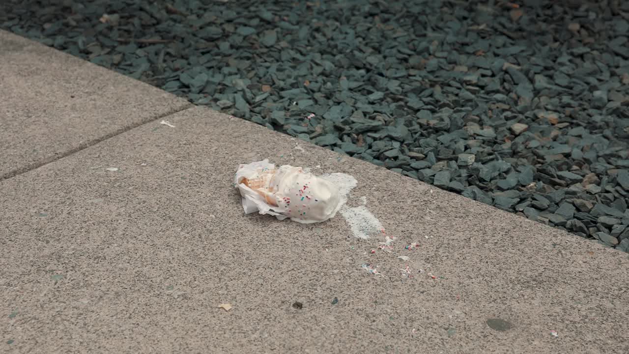 An ice cream cone melts on a hot sidewalk