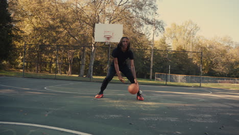 man dribbling basketball on outdoor court