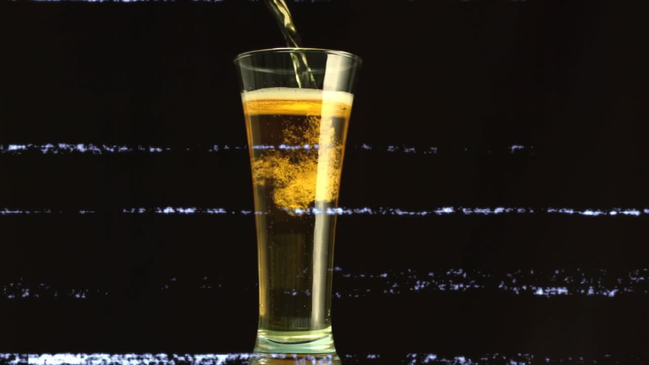 Pouring stream from above starting glass filling, foam forming and bubbles rising to show fizzing