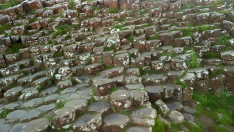 panorámica aérea de izquierda a derecha de las piedras de basalto en la calzada del gigante, condado de antrim en irlanda del norte en una mañana soleada