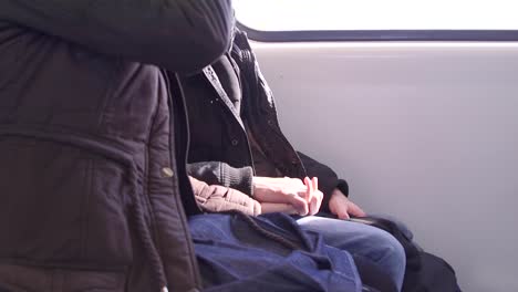 woman and man holding hands on a train