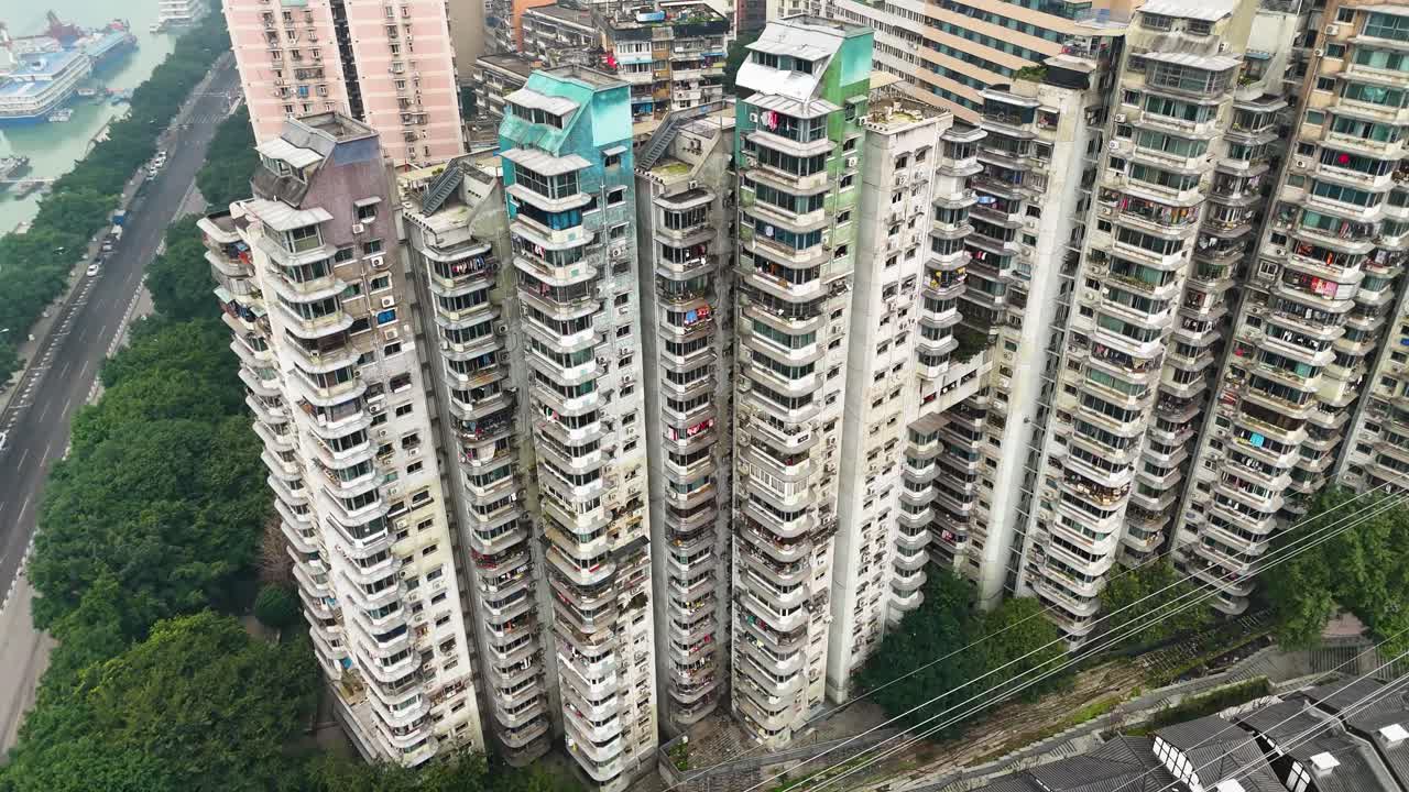 Aerial view of old apartment buildings in Chongqing, China, showcasing the densely packed residential structures with a mix of worn exteriors, highlighting urban living in the city.
