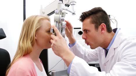 optometrista examinando a una paciente en un phoropter