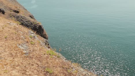 Standing-on-the-edge-of-the-Helliwell-meadow-cliffs-looking-down-at-the-beautiful-ocean-waters-on-Hornby-Island-in-British-Columbia,-Canada