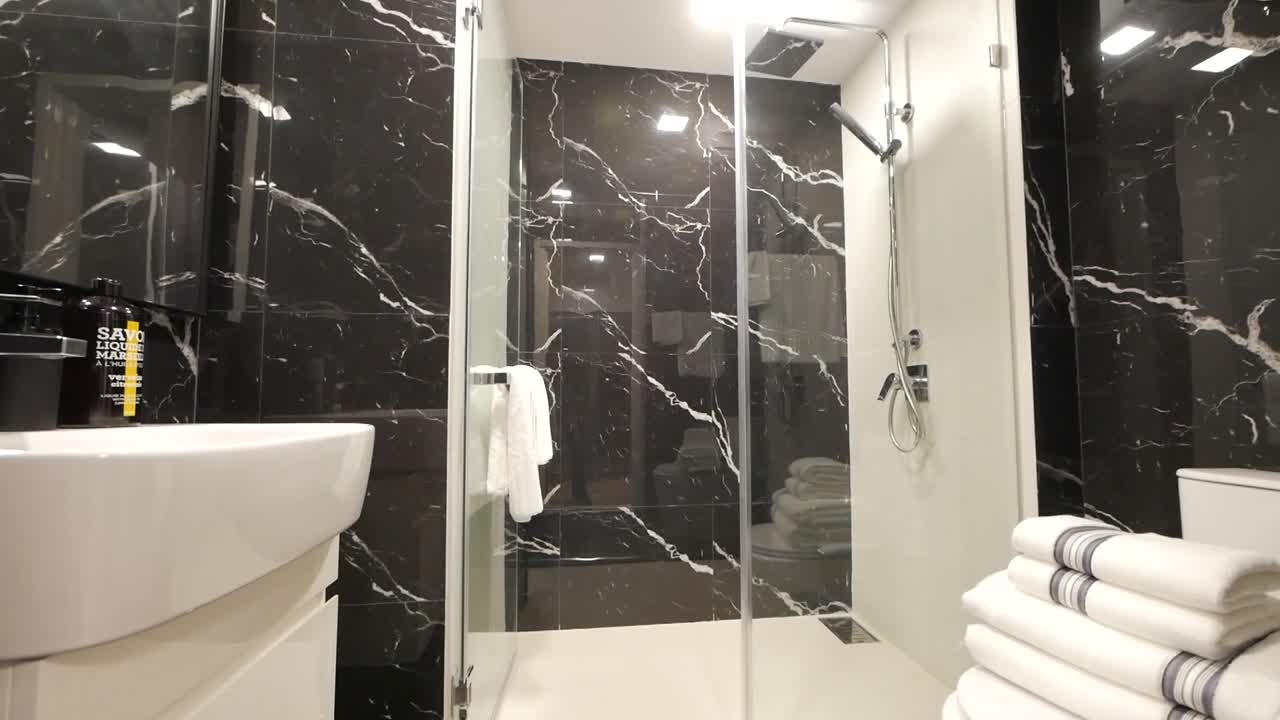 Elegant badeværelse med marmormønstret vægdekoration.