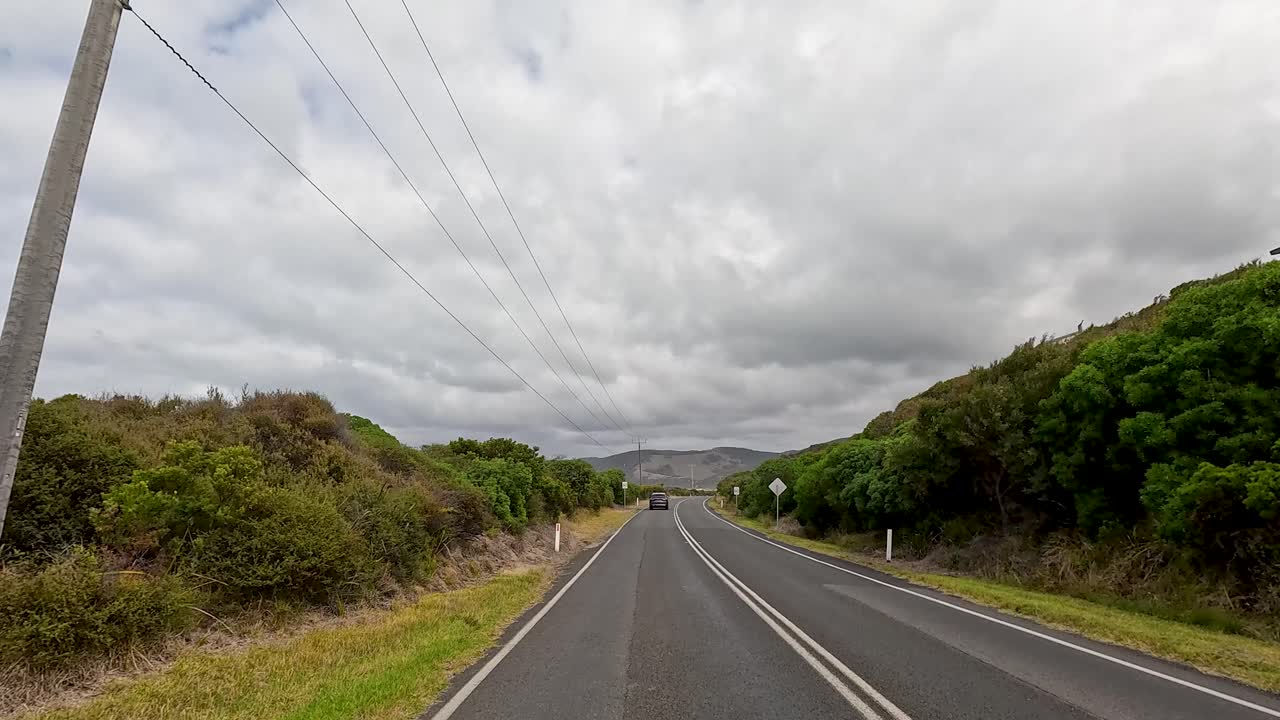 A 45-second video captures a serene drive along the Great Ocean Road, showcasing lush greenery and overcast skies