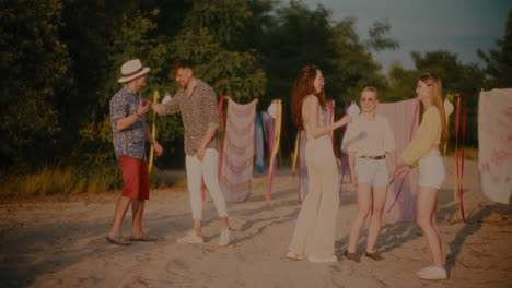 amigos hombres y mujeres felices hablando en la playa.