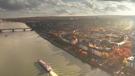 revealing shot in golden light aerial shot of mainz in germany by a drone with the dome in the back showing the city of biontech in front of the rhine river