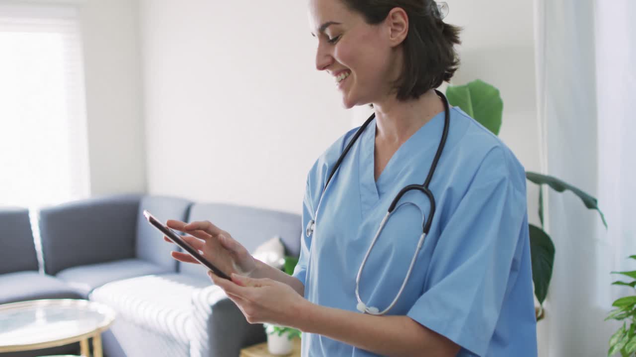 Médica caucásica en casa usando una tableta