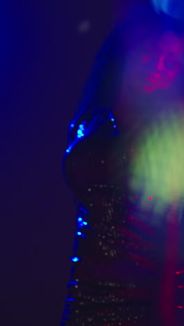 Vertical-Video-Of-Young-Woman-In-Nightclub-Bar-Or-Disco-Dancing-With-Sparkling-Lights-In-Background-3