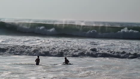 silhouette of people enjoys massive waves of pacific ocean in los angeles