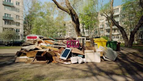 escombros y muebles metidos en el depósito de chatarra junto al contenedor de basura